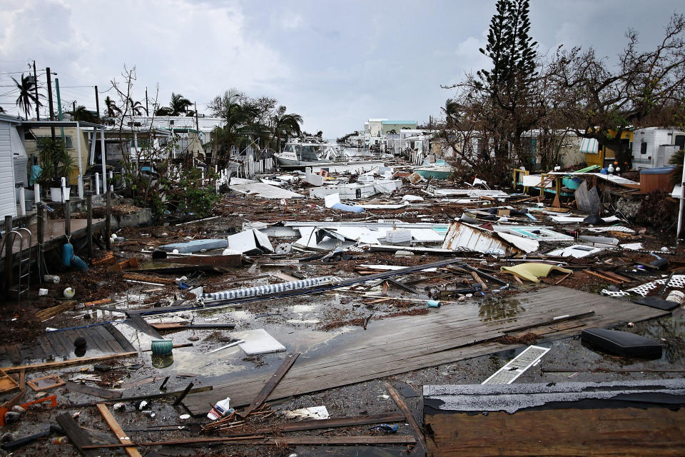 A canal in a trailer park littered with debris and campers. 