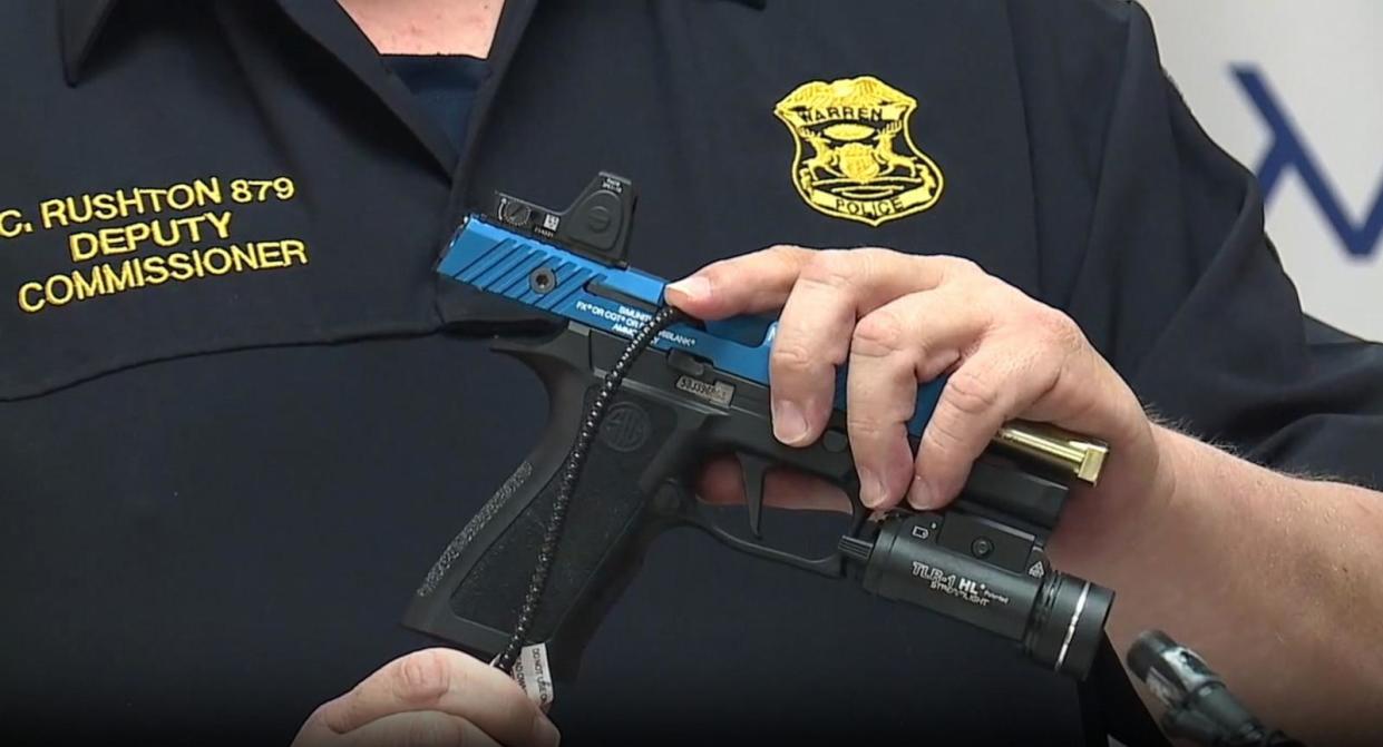 PHOTO: Acting Warren Police Commissioner Charles Rushton demonstrates how a gun lock works at a news conference on April 24, 2024. (WXYZ)