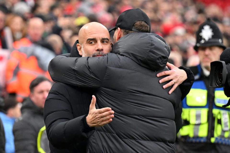 Klopp and Guardiola hug on the touchline at Anfield (Getty)