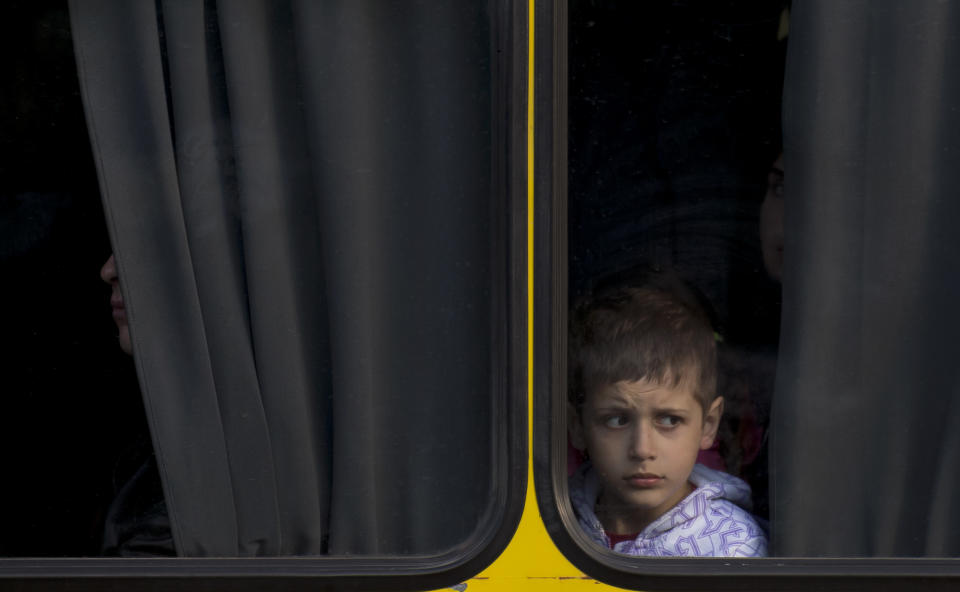 A child looks from inside a bus in Odessa, Ukraine, Tuesday, May 13, 2014. Pro-Russian separatists in Eastern Ukraine held a referendum Sunday and claimed that about 90 percent of those who voted in Donetsk and Luhansk backed sovereignty. The two regions declared independence on Monday and insurgents in Donetsk even asked to join Russia. (AP Photo/Vadim Ghirda)