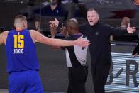 Denver Nuggets' Nikola Jokic (15) and head coach Michael Malone, right, react as referee Courtney Kirkland, center, charges a foul against Jokic during the first half an NBA conference final playoff basketball game against the Los Angeles Lakers on Friday, Sept. 18, 2020, in Lake Buena Vista, Fla. (AP Photo/Mark J. Terrill)