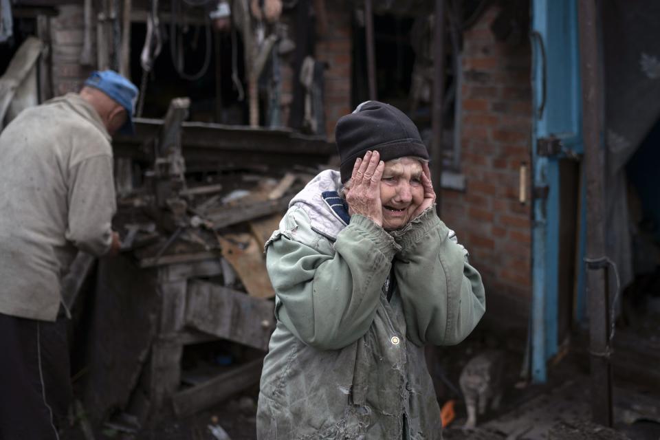 FILE - Valentina Bondarenko reacts as she stands with her husband Leonid outside their house that was heavily damaged after a Russian attack in Sloviansk, Ukraine, on Sept. 27, 2022. The 78-year-old woman was in the garden and fell on the ground at the moment of the explosion. "Everything flew and I started to run away", says Valentina. (AP Photo/Leo Correa, File)