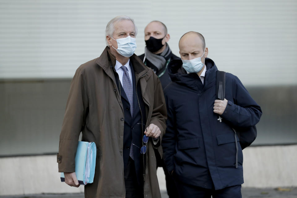 EU Chief Negotiator Michel Barnier, left, waits to cross the street as he walks to attend Brexit trade negotiations at a conference centre, in London, Tuesday, Dec. 1, 2020. Teams from Britain and the European Union are continuing face-to-face talks on a post-Brexit trade deal with little time remaining. (AP Photo/Matt Dunham)