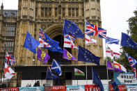 Various flags flutter in the wind outside the houses of Parliament in London, Monday, Oct. 21, 2019. There are just 10 days until the U.K. is due to leave the European bloc on Oct. 31.(AP Photo/Alberto Pezzali)