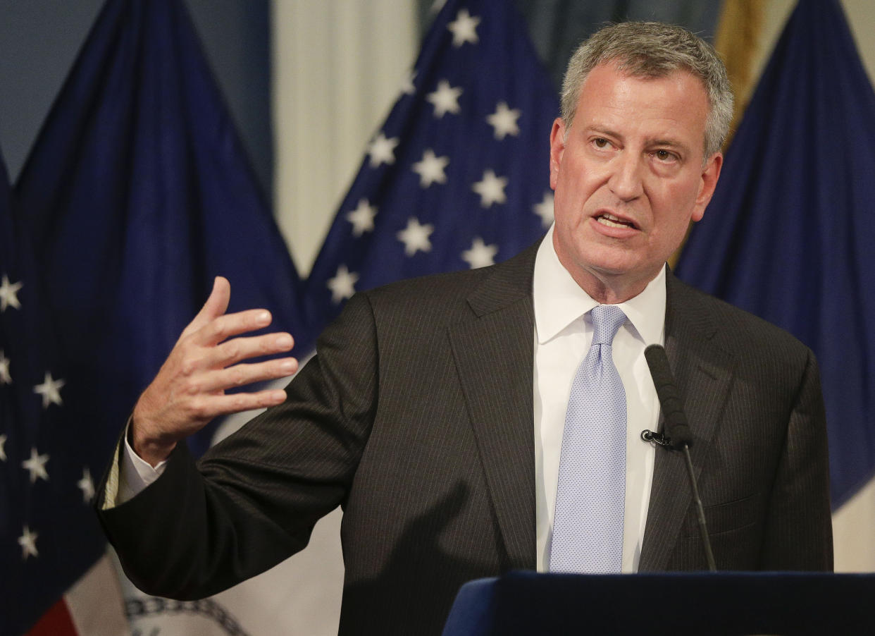 New York City Mayor Bill de Blasio stands at a podium as he speaks. 