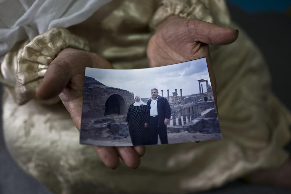 <p>Amineh Hamad, 58, a Syrian refugee from Eastern Ghouta near Damascus, shows a photograph of herself and her husband Ali Abdulqader, 58, at her shelter in the Ritsona refugee camp, Greece, Jan. 7, 2017. “It was the last time we visited the Roman site of Busra al-Sham, a sunny Friday during the summer of 2010, we had a barbecue, walked and laughed a lot, a day from life, we miss these days, we hope one day it will come back.” Amineh said. (Photo: Muhammed Muheisen/AP) </p>