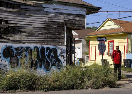 A man walks past an abandoned building in the Upper Ninth Ward neighborhood of New Orleans, Louisiana, August 1, 2015. REUTERS/Jonathan Bachman