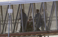 A person in a wheelchair is taken off the cruise ship Rotterdam at Port Everglades, Thursday, April 2, 2020, in Fort Lauderdale, Fla. A cruise ship that has been floating at sea with coronavirus patients aboard for two weeks after being turned away from South American ports was finally allowed to dock in Florida. The Zaandam and a sister ship sent to help it, the Rotterdam, were both given permission to disembark passengers after days of negotiation with local officials who feared it would divert needed resources from a region that has seen a spike in virus cases. (AP Photo/Wilfredo Lee)