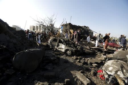 People gather at the site of an air strike at a residential area near Sanaa Airport March 26, 2015. REUTERS/Khaled Abdullah