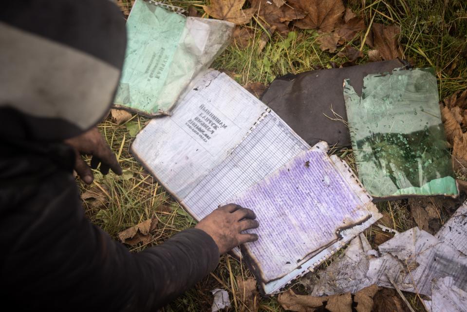 A man looks through a Russian journal found inside a destroyed Russian military vehicle yesterday in Kherson, Ukraine (Getty Images)