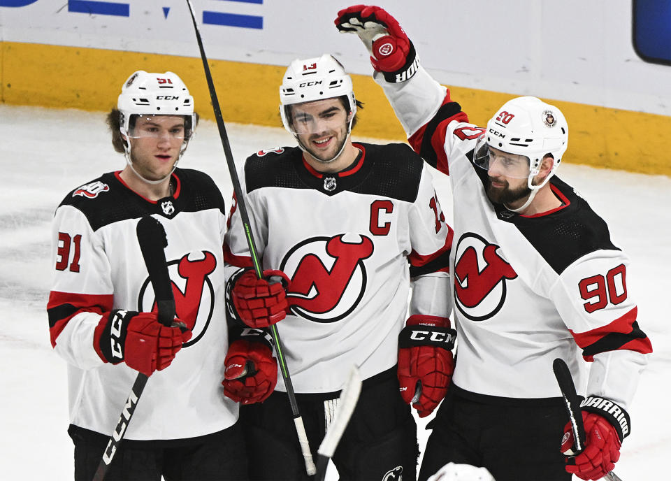 New Jersey Devils' Nico Hischier (13) celebrates his goal against the Montreal Canadiens with Tomas Tatar (90) and Dawson Mercer (91) during the first period of an NHL hockey game Saturday, March 11, 2023, in Montreal. (Graham Hughes/The Canadian Press via AP)