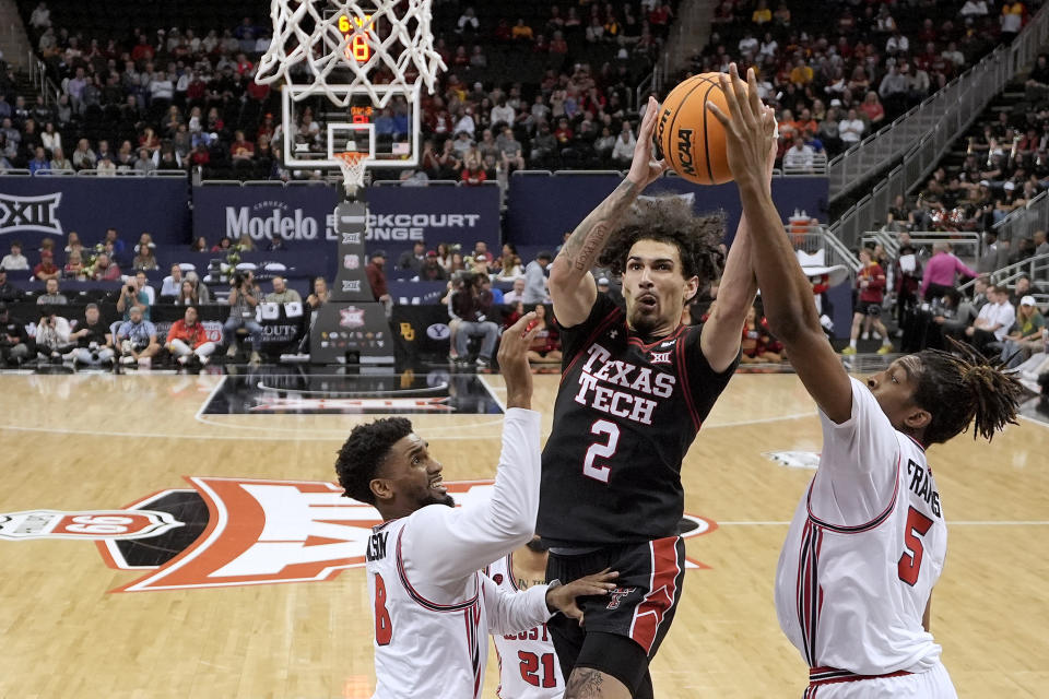 Texas Tech guard Pop Isaacs (2) shoots between Houston guard Mylik Wilson (8) and forward Ja'Vier Francis (5) during the first half of an NCAA college basketball game in the semifinal round of the Big 12 Conference tournament, Friday, March 15, 2024, in Kansas City, Mo. (AP Photo/Charlie Riedel)