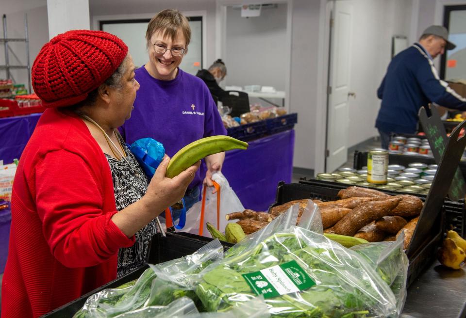 Carolyn Lameri, center, a volunteer at Daniel's Table, assists a shopper during the opening day of the nonprofit's farmers market inside its new temporary location at 56 Park St. in Framingham, April 24, 2024. Daniel's Table's headquarters at 10 Pearl St. will be demolished and then replaced with a six-story, mixed-use building, with the nonprofit occupying the ground floor.