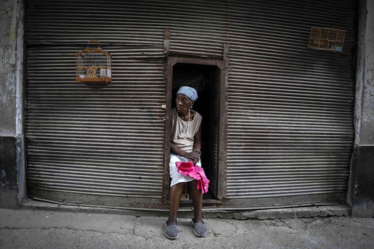 Una mujer que vende bolsas de plástico para la compra, espera a los clientes en La Habana, Cuba, el sábado 9 de julio de 2022.