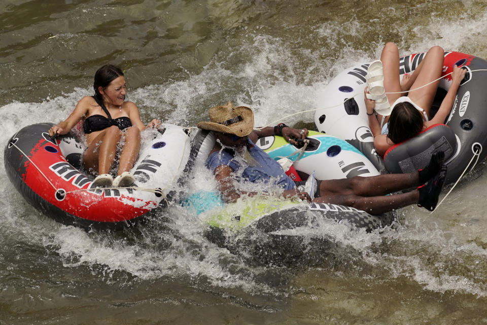Tubers float the cool waters of the Comal River, Tuesday, June 14, 2022, in New Braunfels, Texas. (AP Photo/Eric Gay)