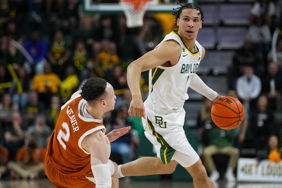 Baylor's Miro Little, right, dribbles past Texas's Chendall Weaver (2) during the first half of an NCAA college basketball game, Monday, March 4, 2024, in Waco, Texas. (AP Photo/Julio Cortez)