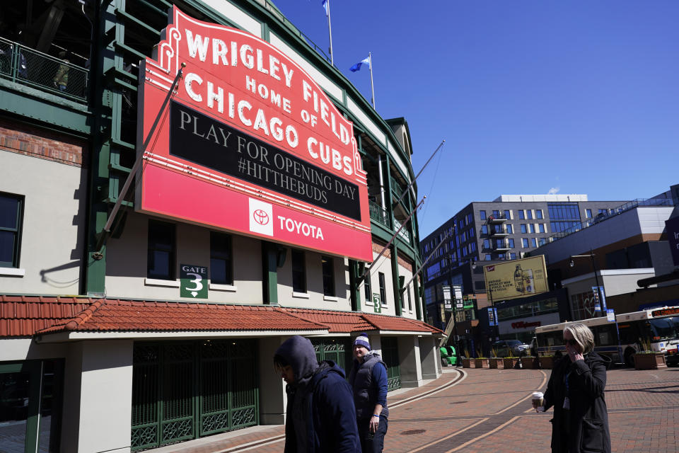 CORRECTS YEAR TO 2023 NOT 2022 - People stand outside Wrigley Field in Chicago, Monday, March 27, 2023, the venue for this Thursday's opening day baseball game between the Milwaukee Brewers and the Chicago Cubs. (AP Photo/Nam Y. Huh)