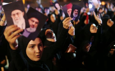 Female supporters of Lebanon's Hizbollah leader Sayyed Hassan Nasrallah chant slogans as he addresses his supporters via a screen - Credit: Reuters