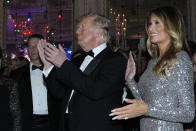 Former President Donald Trump and former first lady Melania Trump arrive in the dining room for a New Years Eve party at Mar-a-Lago, in Palm Beach, Fla., Saturday, Dec. 31, 2022. (AP Photo/Lynne Sladky)