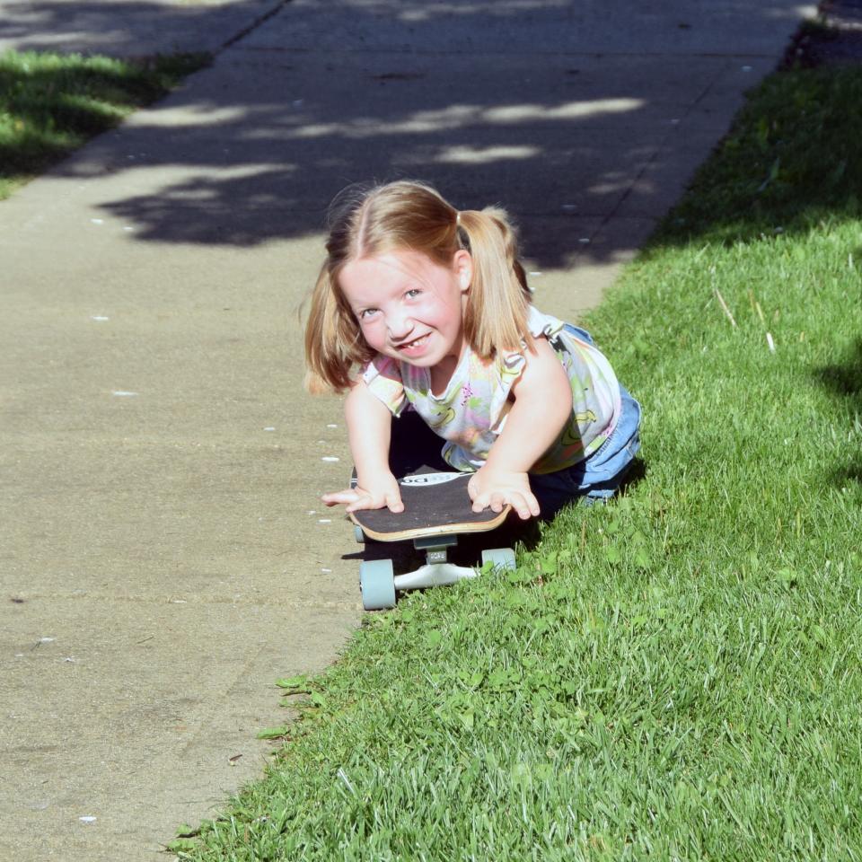 Ellie Messer plays with a skateboard at her Etna Township home.