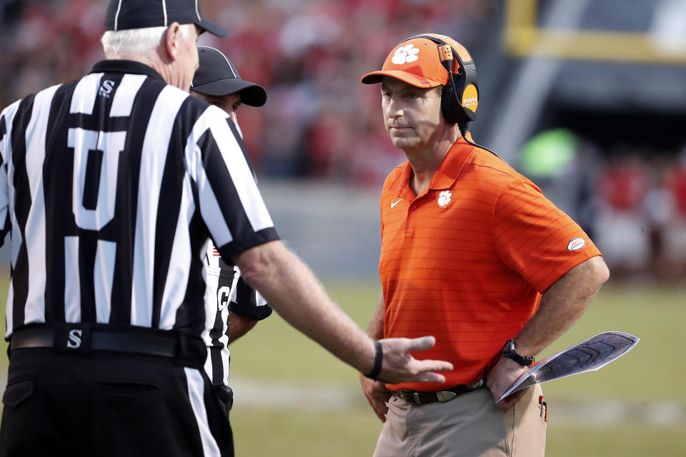 Clemson head coach Dabo Swinney, right, speaks with officials during the second half of an NCAA college football game against North Carolina State in Raleigh, N.C., Saturday, Sept. 25, 2021. (AP Photo/Karl B DeBlaker)