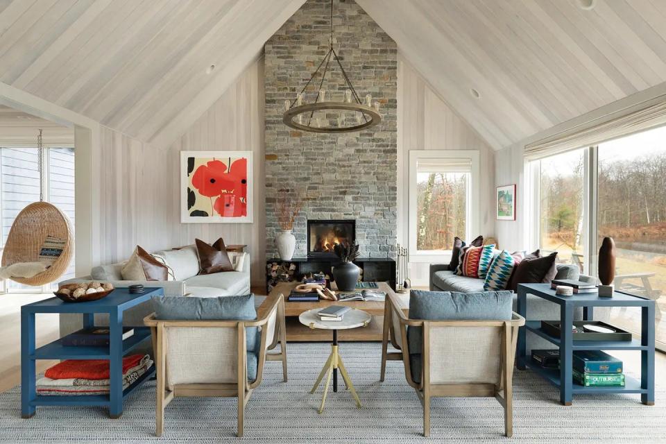 stone fireplace in window-lined livin groom