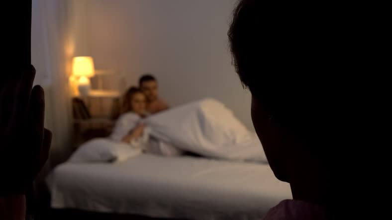 A person walking in on a couple in bed