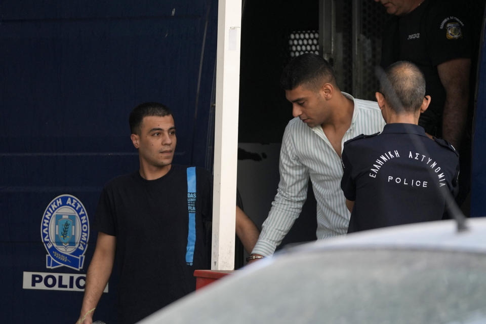Two of nine Egyptian men accused of causing a shipwreck last year that killed hundreds of migrants arrive at a courthouse for the start of their trial in Kalamata, southwestern Greece, Tuesday, May 21, 2024. The defendants face up to life in prison if convicted on multiple criminal charges. (AP Photo/Thanassis Stavrakis)