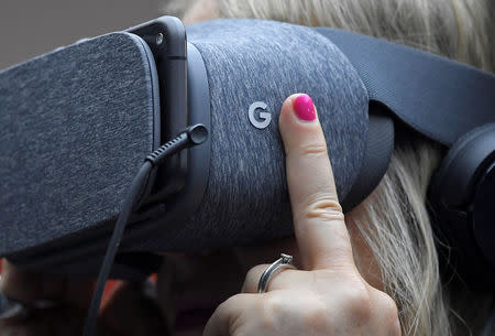 An attendee wears VR goggles at the Google digital workshop stand at the Labour Party Conference venue in Brighton, Britain, September 26, 2017. REUTERS/Toby Melville