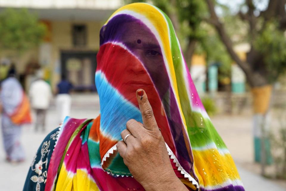 A woman shows her inked finger after casting her vote in India’s general elections at a polling station in Nagaur in the western state of Rajasthan on 19 April 2024 (AFP via Getty Images)