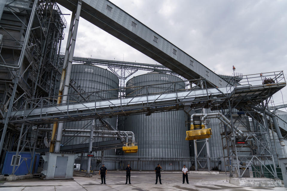 Security personnel stand in front of a grain storage terminal at the Odesa Sea Port, in Odesa, Ukraine, Friday, July 29, 2022. (AP Photo/David Goldman)