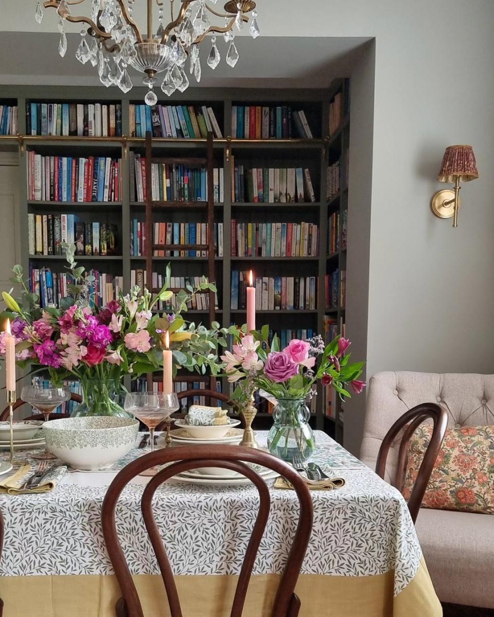 a table with a vase of flowers and candles on it