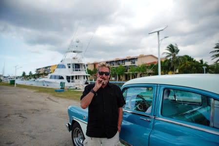 John McAfee smokes a cigarette before taking a taxi at the Marina Hemingway in Havana