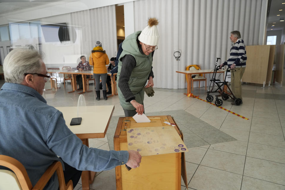 A woman casts her ballot at a polling station during parliamentary election in Turku, Finland, Sunday, April 2, 2023. (AP Photo/Sergei Grits)