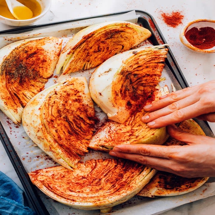 cabbage wedges being rubbed with spices