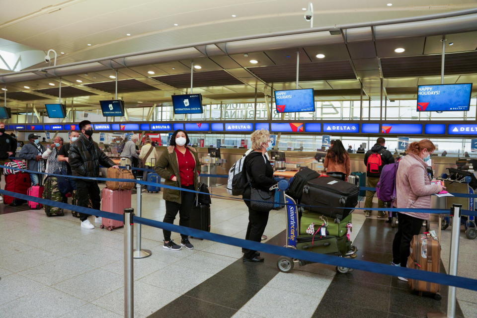 Passengers line up at John F. Kennedy International Airport after airlines announced numerous flights were canceled during the spread of the Omicron coronavirus variant on Christmas Eve in Queens, New York City, U.S., December 24, 2021. REUTERS/Dieu-Nalio Chery REFILE - QUALITY REPEAT