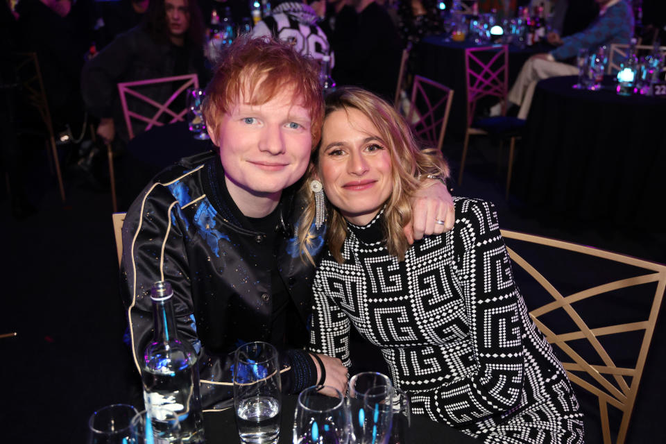 Ed with his arm around Cherry as they sit at a table