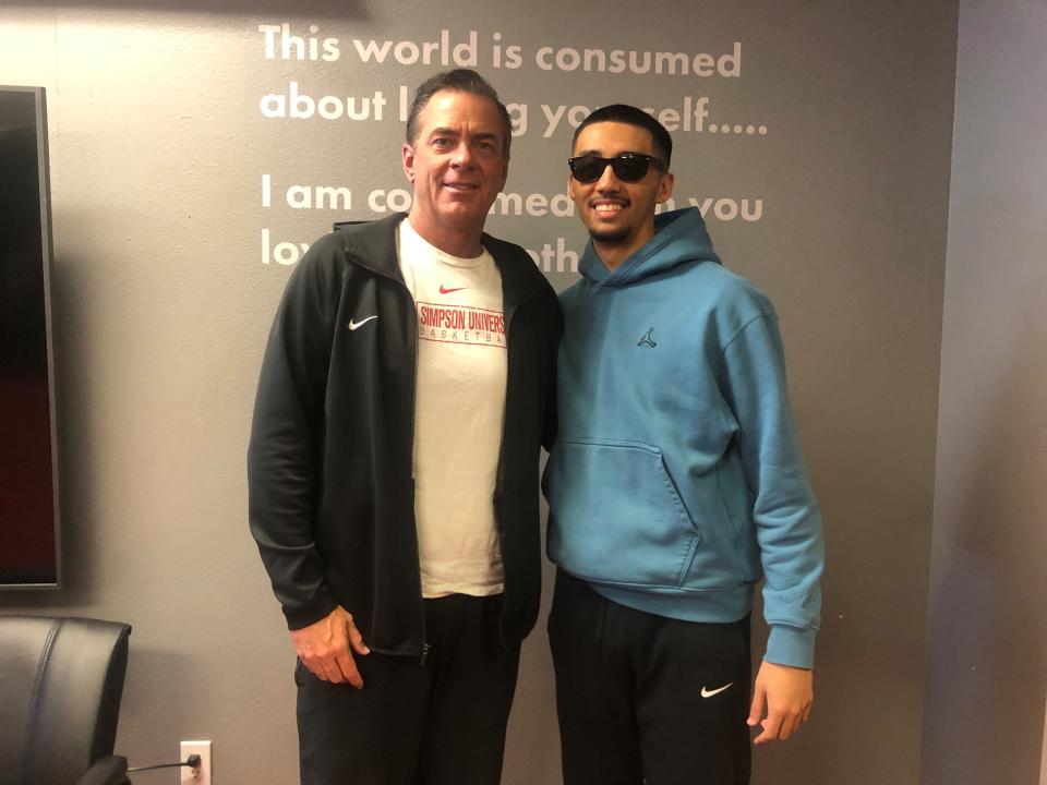 Simpson University junior guard Kevin Robello (right) wearing sunglasses to protect his eyes, poses with coach Todd Franklin in the players room on Tuesday, Feb. 7, 2023.