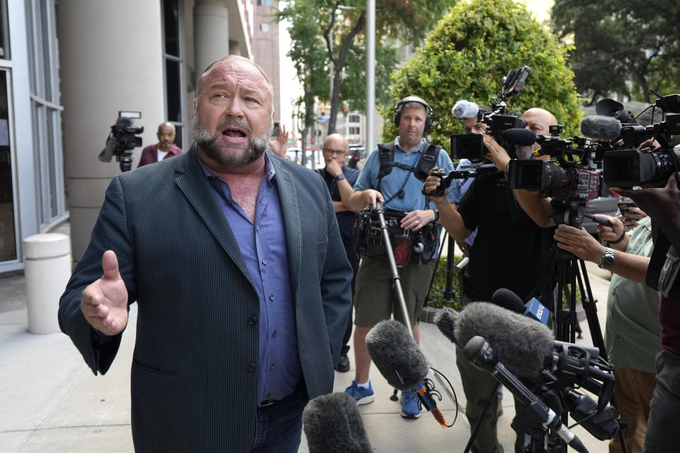 Right-wing conspiracy theorist Alex Jones speaks to the media as he arrives at the federal courthouse for a hearing in front of a bankruptcy judge Friday, June 14, 2024, in Houston. The judge is expected to rule on whether to liquidate Jones' assets to help pay the $1.5 billion he owes for his false claims that the Sandy Hook Elementary School shooting was a hoax. (AP Photo/David J. Phillip)