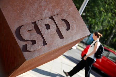 FILE PHOTO: Person walks past the logo of Germany's SPD at the party's headquarters in Berlin