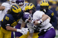 Northwestern quarterback Ryan Hilinski is sacked by Michigan defensive ends Mike Morris (90) and Aidan Hutchinson during the first half of an NCAA college football game, Saturday, Oct. 23, 2021, in Ann Arbor, Mich. (AP Photo/Carlos Osorio)