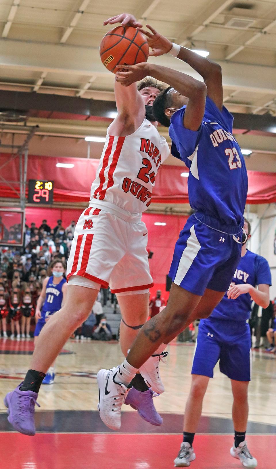 North Quincy's Dylan Clifford blocks a layup attempt by Quincy's Jordan Davis during a game on Friday, Jan. 21, 2022.