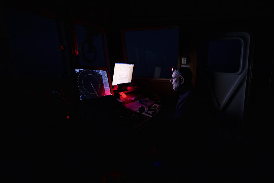 49-year-old 'Erri' from Bilbao in Spain, Chief Mate of the Spanish NGO Open Arms vessel, analyses the latest data on the ship's position and direction during a watch a few hours before dawn in the Mediterranean Sea, Saturday Feb.6, 2021. Various African migrants drifting in the Mediterranean Sea after fleeing Libya on unseaworthy boats have been rescued. In recent days, the Libyans had already thwarted eight rescue attempts by the Open Arms, a Spanish NGO vessel, harassing and threatening its crew in international waters. (AP Photo/Bruno Thevenin)