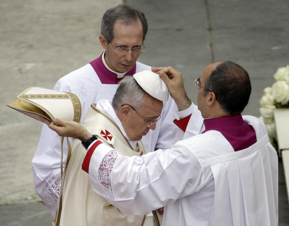 Pope Francis gets his skullcap adjusted as he leads a solemn ceremony in St. Peter's Square at the Vatican, Sunday, April 27, 2014. Pope Francis has declared his two predecessors John XXIII and John Paul II saints in an unprecedented canonization ceremony made even more historic by the presence of retired Pope Benedict XVI. (AP Photo/Gregorio Borgia)