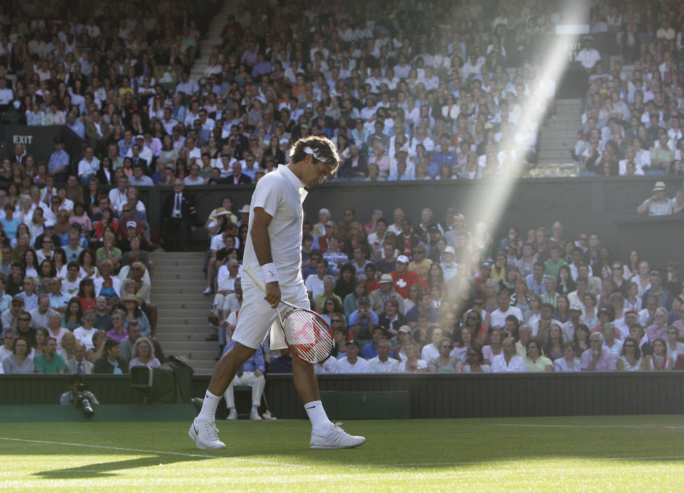 FILE - In this Wednesday, June 25, 2008 file photo made by Associated Press photographer Anja Niedringhaus, Switzerland's Roger Federer walks across the court as a shaft of late afternoon light illuminates the Centre Court during his second round match against Sweden's Robin Soderling at Wimbledon, England. Niedringhaus, 48, an internationally acclaimed German photographer, was killed and an AP reporter was wounded on Friday, April 4, 2014 when an Afghan policeman opened fire while they were sitting in their car in eastern Afghanistan. (AP Photo/Anja Niedringhaus, File)