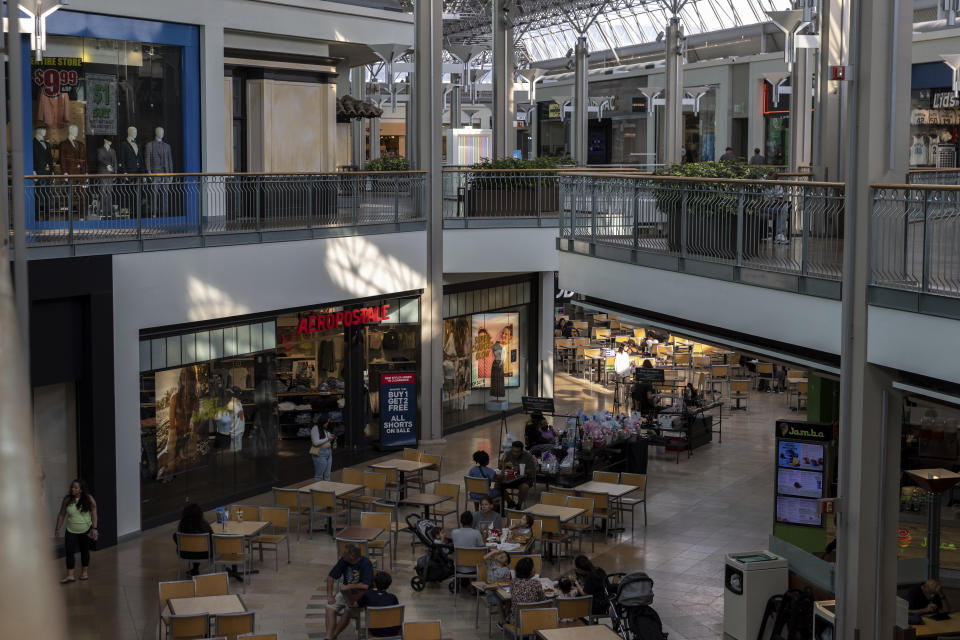 People sit at tables at the Mall in Columbia, Friday, May 12, 2023, in Columbia, Md. The mall has implemented a "Parental Guidance Required" program, which requires that all visitors under 18 be accompanied by an adult who is at least 21-years-old after 4 p.m. on Fridays and Saturdays. (AP Photo/Julia Nikhinson)