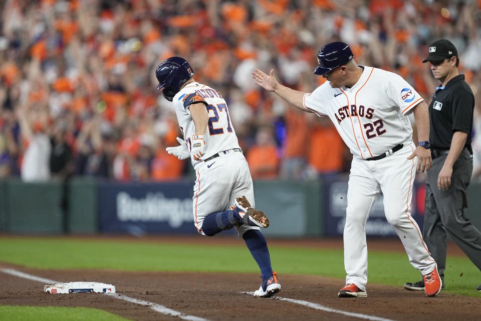 Houston Astros' Jose Altuve is greeted by first base coach Omar López after a solo home run during the first inning in Game 1 of an American League Division Series baseball game against the Minnesota Twins, Saturday, Oct. 7, 2023, in Houston. (AP Photo/Tony Gutierrez)