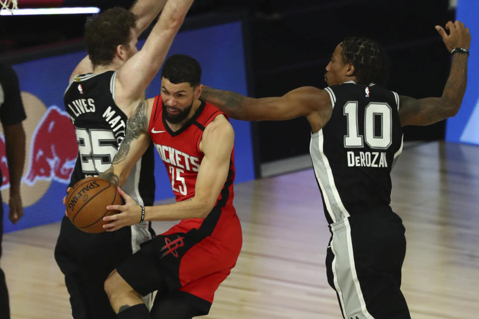 Houston Rockets guard Austin Rivers (25) drives to the basket while San Antonio Spurs center Jakob Poeltl (25) and forward DeMar DeRozan (10) defend during the second half of an NBA basketball game Tuesday, Aug. 11, 2020, in Lake Buena Vista, Fla. (Kim Klement/Pool Photo via AP)