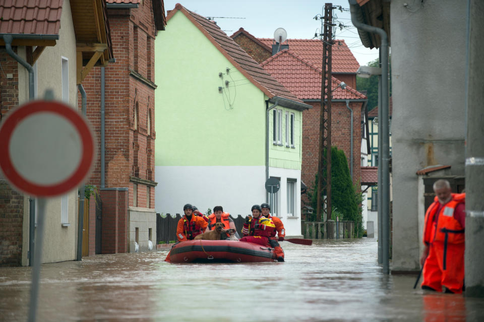 <p>Mitarbeiter der Deutschen Lebens-Rettungs-Gesellschaft DLRG bringen in Harsleben, Sachsen-Anhalt, mit einem Schlauchboot zwei Hunde und eine Bewohnerin ins Trockene. Weite Teile des Ortes sind seit einigen Tagen überflutet. (Bild: Klaus-Dietmar Gabbert/dpa-Zentralbild/dpa) </p>