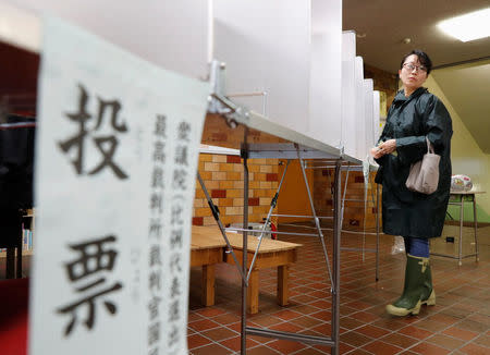 A woman fills out her ballot for a national election at a polling station in Tokyo, Japan October 22, 2017. The sign reads, 'Ballot'. REUTERS/Kim Kyung-Hoon